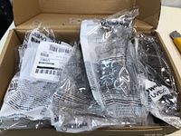 Box containing individually packaged Honeywell Uvex safety glasses with visible clear plastic bags.