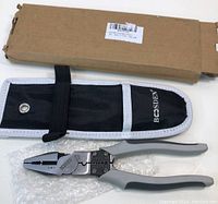 Linesman pliers with gray handles laid on bubble wrap next to a black carrying case and a brown cardboard box