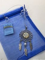 Dream catcher suncatcher laid flat with branded Crystal Art tag and blue organza pouch