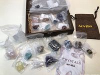 Wooden case containing 20 individually bagged crystals and stones, along with a fabric pouch marked 'Aovila'.