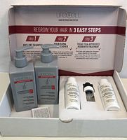 Box interior showing LifeCell hair restoration kit components including shampoo, thickener, regrowth treatment bottles and instructions.