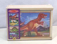 Front view of the Melissa & Doug wooden puzzle set box showing the T-Rex puzzle on the front and packaging details