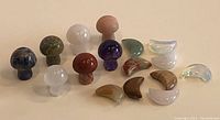 Front view of carved crystal mushrooms and moon-shaped stones arranged on a flat surface.