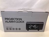 Photo of the product box showing the projection alarm clock model HM433A with features and image.