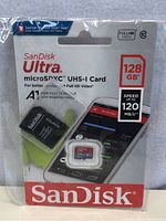 Photo of sealed SanDisk Ultra 128GB microSDXC UHS-I card packaging with adapter, displaying speed and capacity.