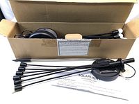 Box containing 4 solar garden stake lights with stakes and LED bulb heads visible, along with product manual.