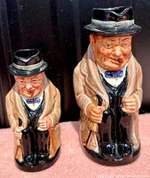 Front view of both jugs side by side showing size difference and facial details