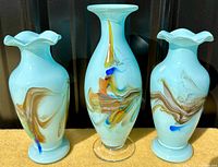 Front view showing all three turquoise swirled glass vases with varied shapes and flared or ruffled rims.