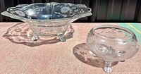 Two authentic Cornflower glass bowls with clear animal-paw feet, one larger with wide scalloped rim, one smaller rounded bowl, both with floral cut glass design.
