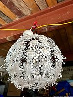 White spherical hanging lamp fixture from Ikea Grimsas collection suspended from ceiling beam, showing full design and structure.