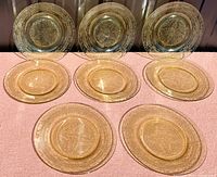 Full view of all six yellow Depression glass dinner plates arranged in two rows to show pattern and size.