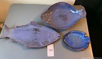 Top view of all three cobalt blue fish-shaped ceramic serving plates laid out together on a table.