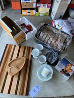 Photo showing the multi-wood cutting board, Norpro apple corer in box, Corelle bowls and coffee cups, nonstick vertical chicken roaster, and Philippe Richard roasting tray.