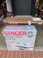 Front view of Singer Magic Press MP4 box on garage floor