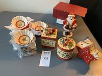 Photo of all ceramic items on table including sets of snack bowls, candle holders, and Santa figure.