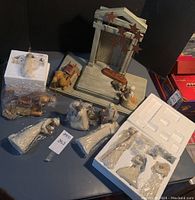 Overview of nativity pieces on tabletop including stable, stars and wrapped figurines