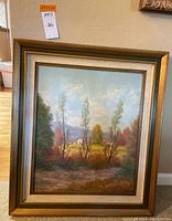 Framed painting signed Cereda depicting a pastoral landscape with trees, fields, and mountains.