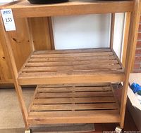 Wooden cart with two visible slatted shelves showing signs of wear and stains