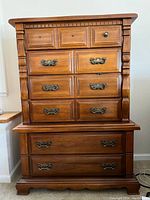 Front view of rustic wooden dresser showing six drawers, with one missing handle on top right drawer and the replacement inside the drawer.