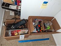 Two cardboard boxes containing assorted power and hand tools