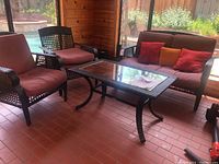Full set on brick flooring: loveseat, two chairs, coffee table, pool backdrop