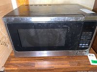 Front view of Black & Decker microwave with digital keypad and display window, shows some surface smudges and dust.