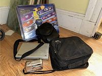 Wide view showing the packaged Polaroid iZone camera, Memorex portable DVD player, two carrying cases, and cords.