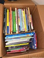 Box with assortment of children's books visible, showing various spines including 'Dictionary for Children'