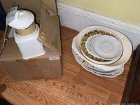 Ceramic serving plates stacked showing gold floral pattern and different sizes.