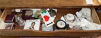 Drawer view showing various crystal and decorative items scattered, including clocks and boxes