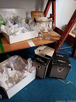Photo showing Block brand colored cocktail glasses along with boxed/glassware items on wooden shelf.