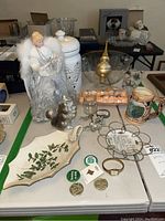 Full view of lot showing Lenox holiday dish with holly leaves, ceramic canister, bear coin bank, crystal bowl, angel figurine, birthday candles and other small items arranged on table.