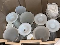 Top view showing multiple white milk glass vases with different shapes and rims packed together