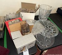 View of the various packed and unpacked glassware and dishes including glasses in boxes and clear glass serving dishes