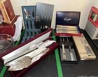 Overview of all cutlery and utensils including boxed Carvel Hall knives, serving utensils, and butler letter opener.