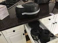 T-Fal Actifry Original air fryer and other appliances on kitchen counter and open cabinet.