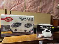 West Bend electric kettle in original box shown alongside Betty Crocker double burner hot plate box
