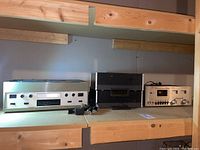Photo showing the Marantz cassette deck 5000X on the left, RCA cassette recorder in middle with carrying case, and another audio component on right shelf.
