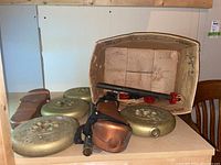 Overview of all items including weight plates, bars, stoppers, and health boots in cardboard box.