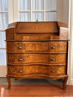 Front view of closed drop-front desk with inlay panels and brass handles