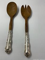 Front view of pair showing ornate silver handles and wooden heads