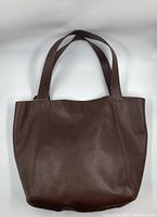 Front view of bag showing shape, straps, and surface wear