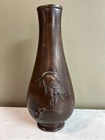 Front view of bronze vase showing bird relief and general shape.