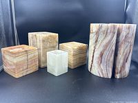 Front view of all six onyx items showing bookends and candle holders with visible chips