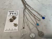 Photo shows seven pieces including four necklaces with pendants and a pair of maple leaf earrings plus a small ankh pendant.