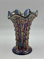 Front view of vintage carnival glass vase showing ruffled top and bubble textured ridges with iridescent colors.