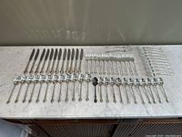 Full layout of all cutlery pieces arranged on marble surface