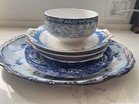 Stack of the serving platter, plates, and noodle bowl showing the full set from above