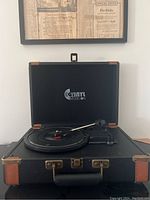 Front view of the closed briefcase record player showing the clasp and handle.