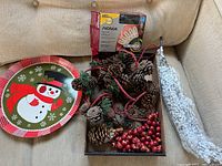 Overview photo showing vintage snowman serving tray, cranberry pine garland, NOMA LED light box, and snow-covered decorative branch in a box.
